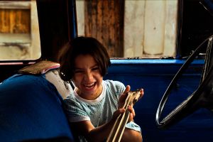 YOUNG GIRL PLAYING IN A OLD CAR